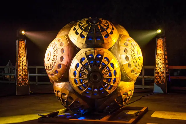 MEGALIGHT v2: escultura central dourada iluminada entre neo-megálitos
