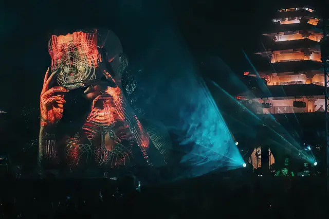 Live visuals no MODEM Festival: projeção de um rosto envolto em linhas, com lasers azuis